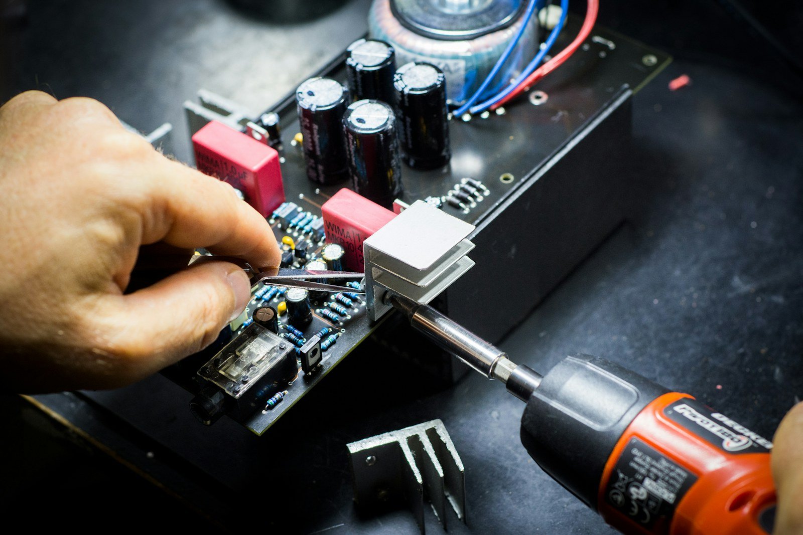 Technician assembling electronics with a driver