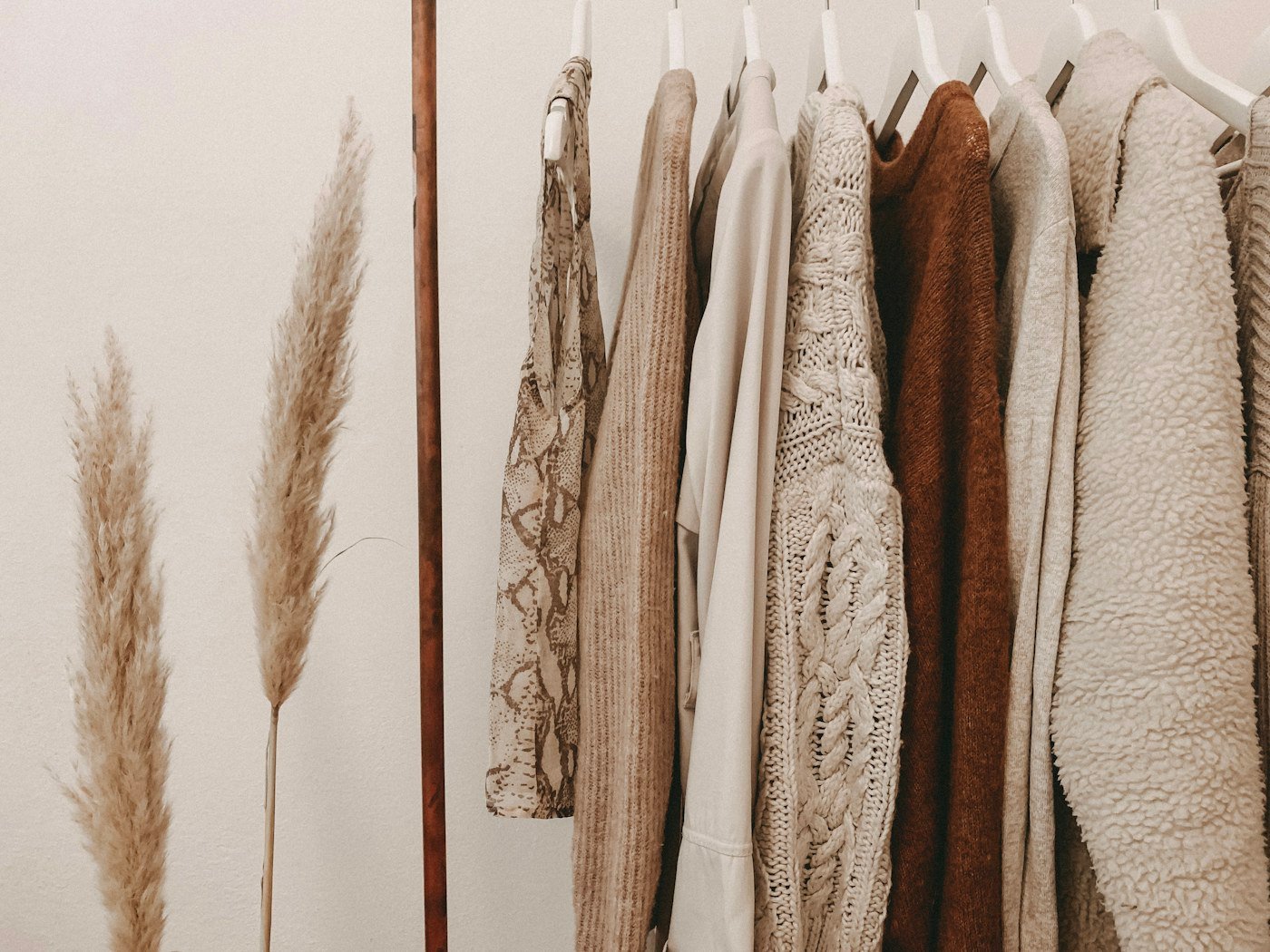 Neutral knit garments hanging on a rail