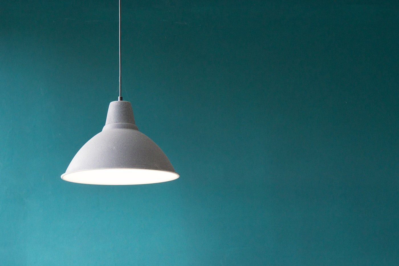 White pendant lamp against a teal wall